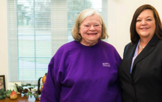 Masonic Village resident with employee, smiling and standing together.