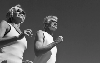 Smiling couple running together outdoors.