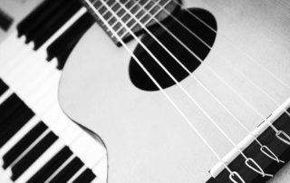 Closeup of a piano and guitar.