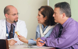 doctor talking to patients at a table.