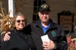 Smiling couple standing outside of store outdoors.