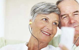 Closeup of happy mature couple listening music together at home