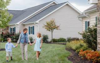 Image of grandmother and grandchildren in front of new cottages at Masonic Village at Elizabethtown