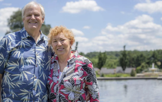 Incoming residents Mike and Jamie stand in front of the reflecting pond in the formal gardens at the Masonic Village at Elizabethtown.
