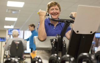 Woman on exercise bike smiling at camera