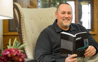 Todd Weitzel, Masonic Village at Elizabethtown, poses with his newly published book.