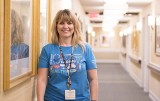 Tracy Shissler, a smiling woman standing in a hallway.
