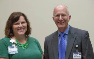 Smiling man and woman standing together indoors.