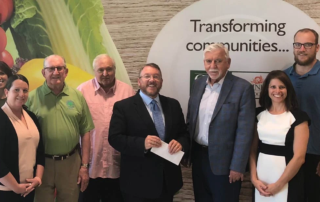Smiling group of adults at a check presentation.