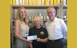 Smiling group of adults holding a check.