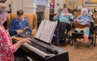 Ann Dinsmore, a smiling woman playing piano as part of music therapy for residents.