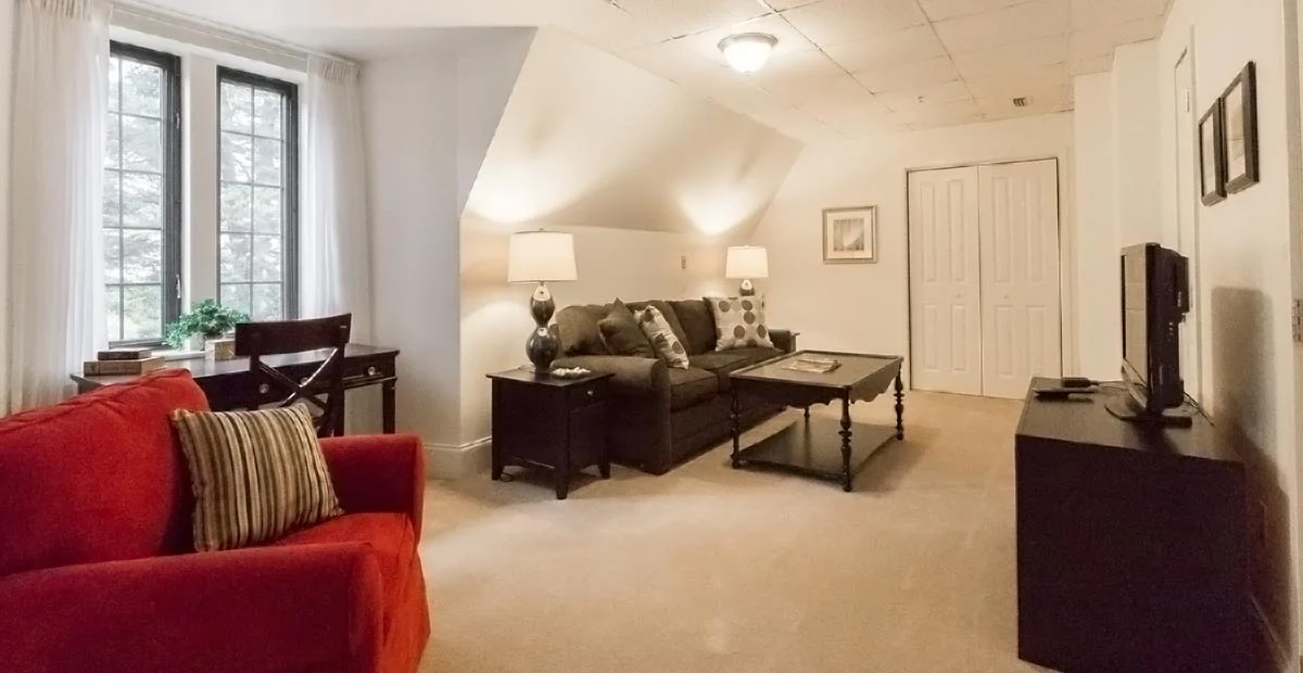 Cozy living room with couch, chair, desk and tv cabinet.