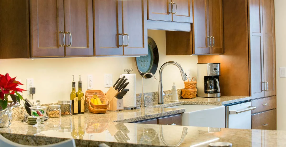 Kitchen in a Masonic Village at Sewickley villa with wood cabinets and farmhouse sink.