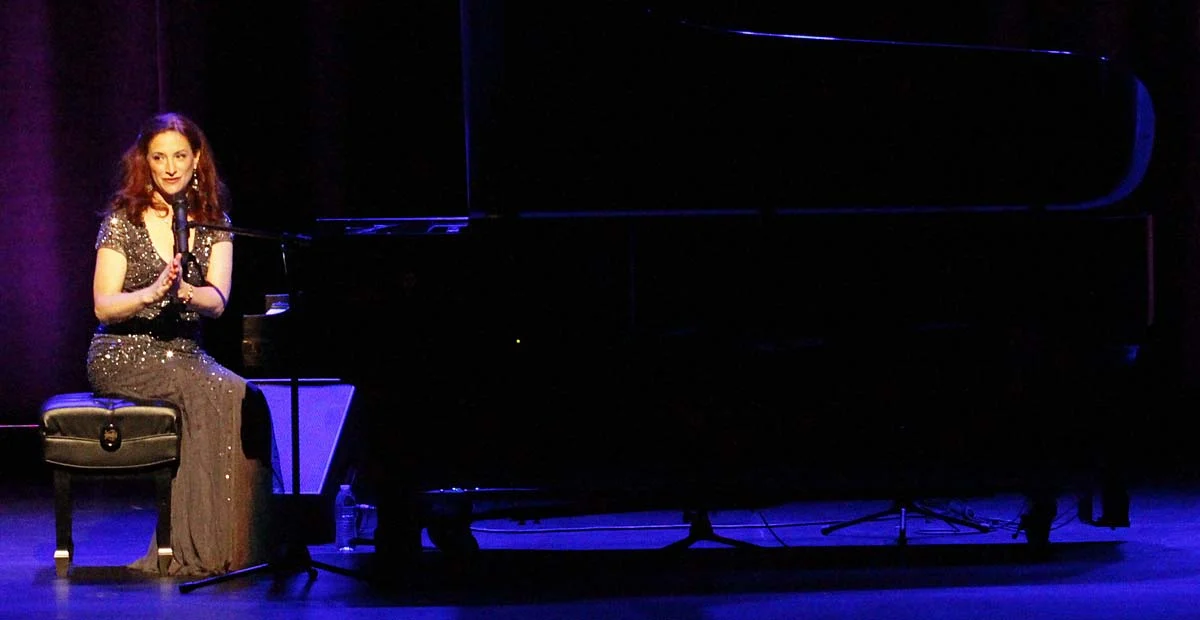 Robin Spielberg, a woman in formal attire sitting at piano.
