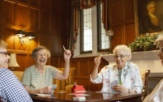 women playing cards at a table.