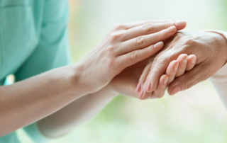 Person holding senior woman's hand.