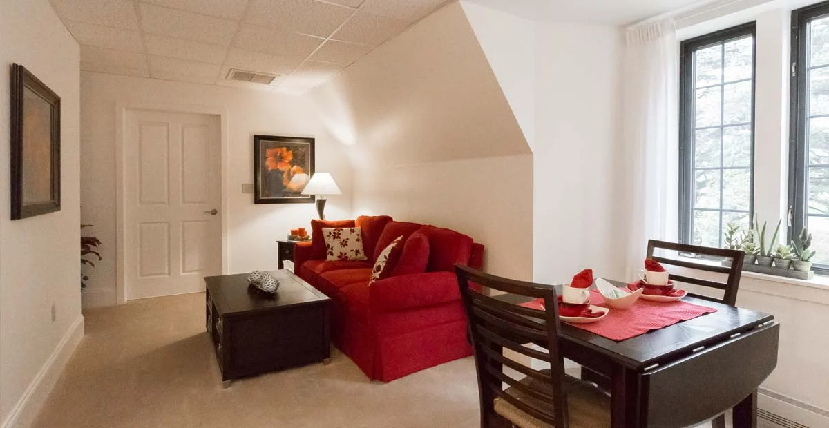 Apartment living room area with kitchen table, couch, and coffee table.