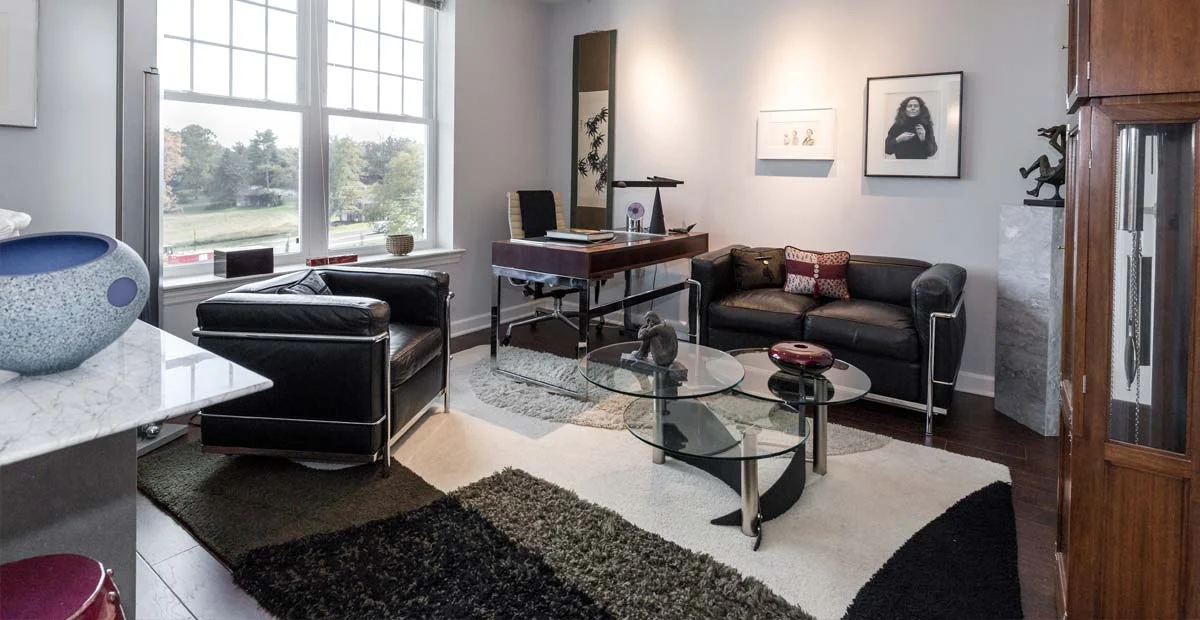 Modern living room with a desk, cabinet, chair and couch.
