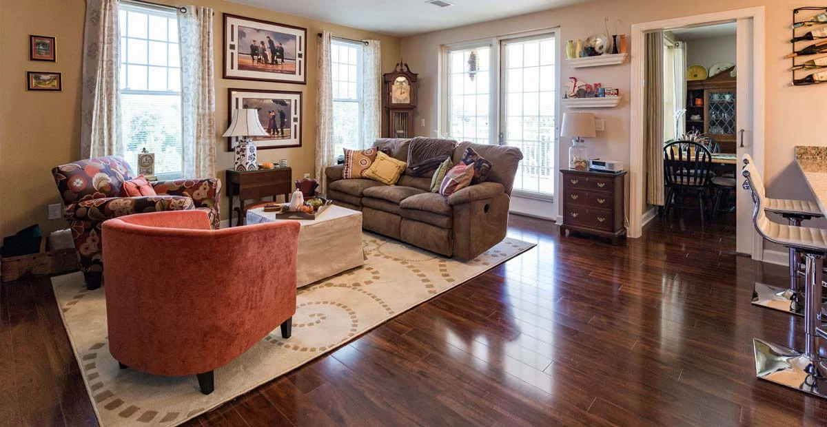 Cozy living room with couch and chairs surrounding a table.