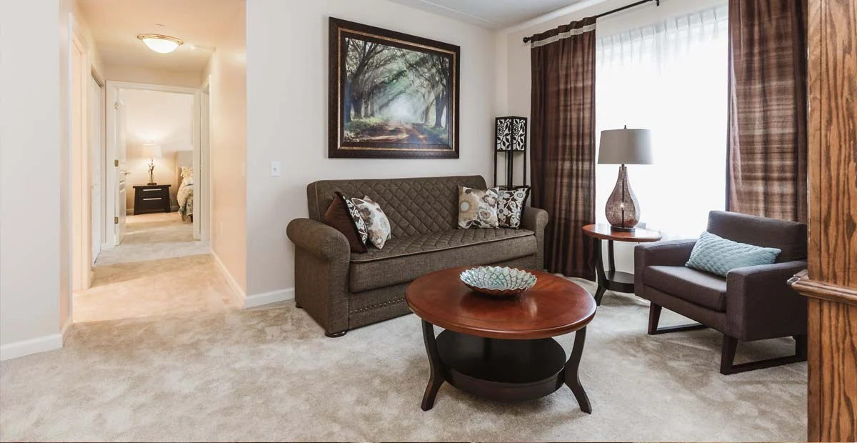 Living room with couch and chair surrounding a table.