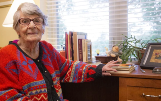 Woman in sweater sitting at her desk.