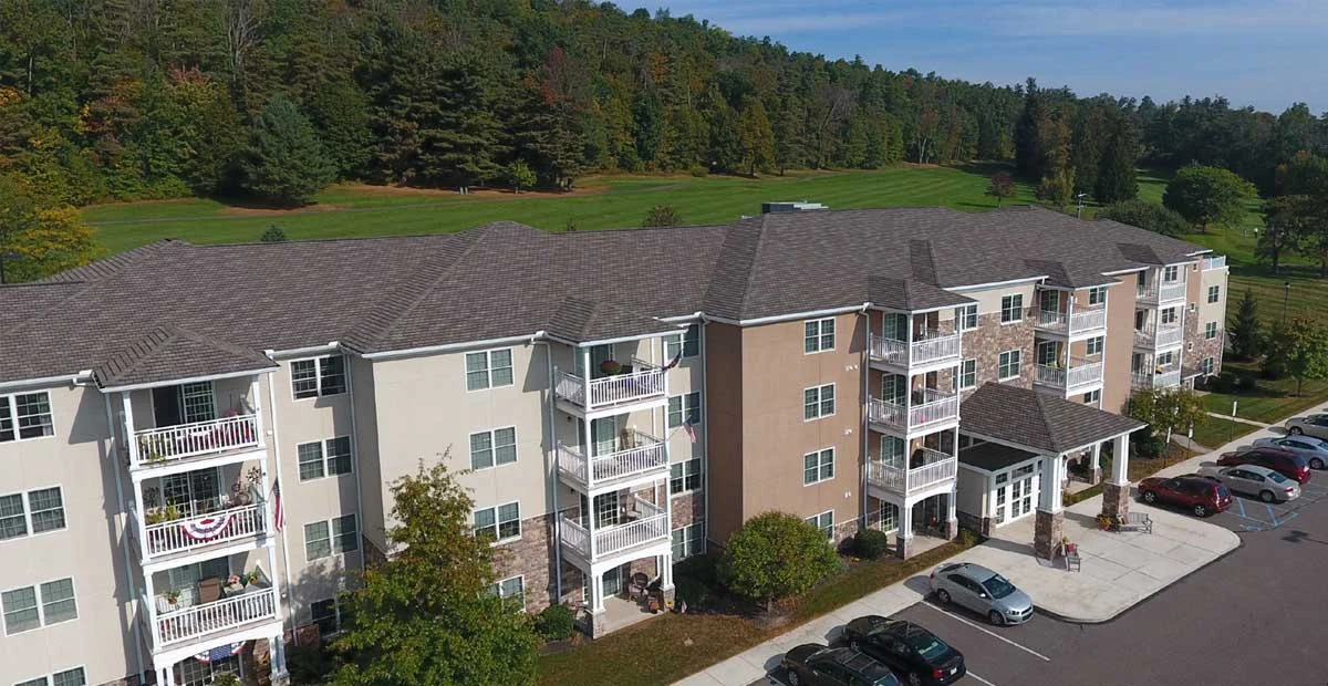 Aerial view of Masonic Village at Dallas, a large apartment building with trees behind it.