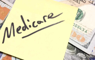 Sticky note with word "Medicare" written on it, posted on pile of money.