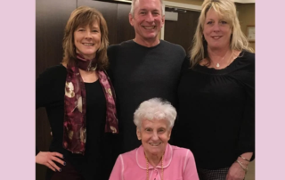 Intergenerational photo featuring senior woman with her adult children.