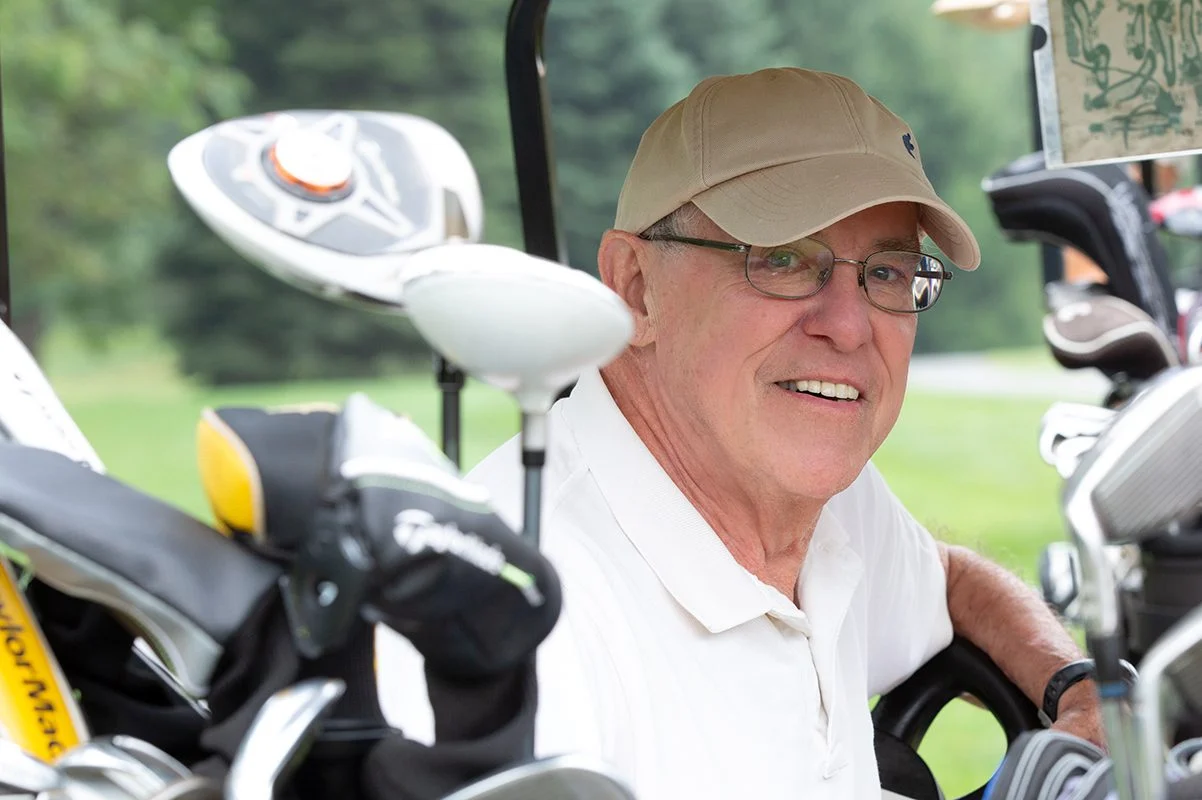 Resident smiling while sitting in golf cart.