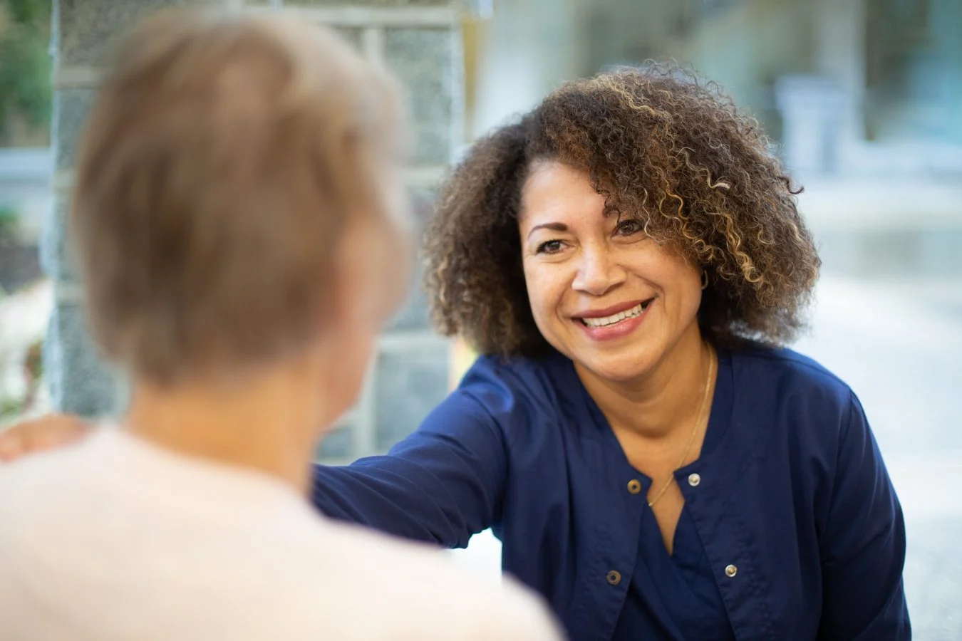 Hospice doctor smiling while talking with patient.