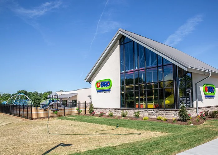Exterior of U GRO childcare center, a large white building with a playground.