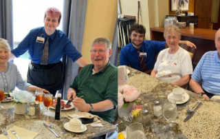 Scholarship recipients with residents in dining rooms.
