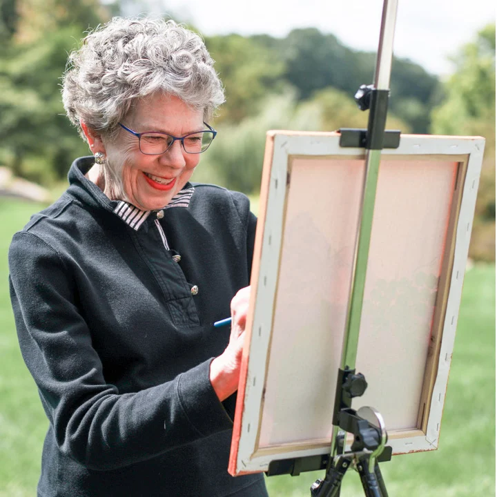 2V9A2114 (1) Woman smiling while painting outdoors