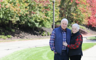 Smiling couple outdoors by tree-lined street