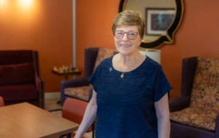 Smiling woman in glasses standing indoors