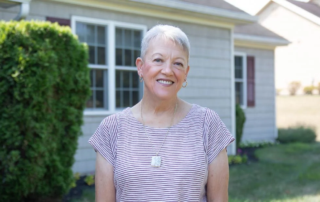 Smiling woman in front of home