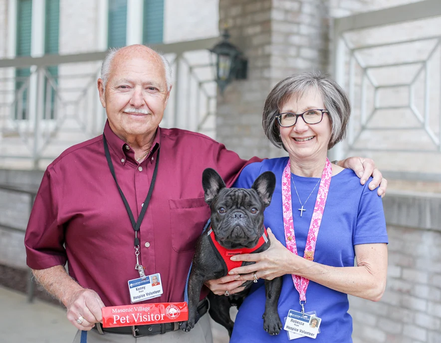 2V9A59892 Smiling man and woman volunteers with dog in the middle.