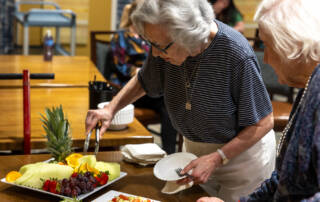 Woman serving herself fruits from tray