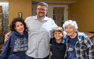 Intergenerational photo of smiling family at screening of PBS documentary.