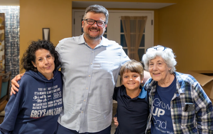 Intergenerational photo of smiling family at screening of PBS documentary.
