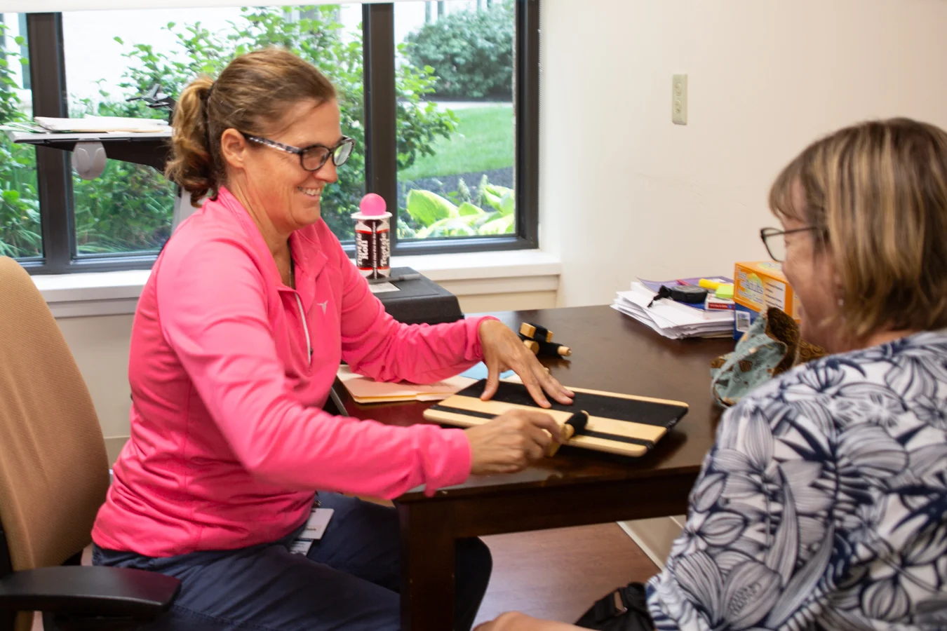 Two women having a discussion at a table indoors.
