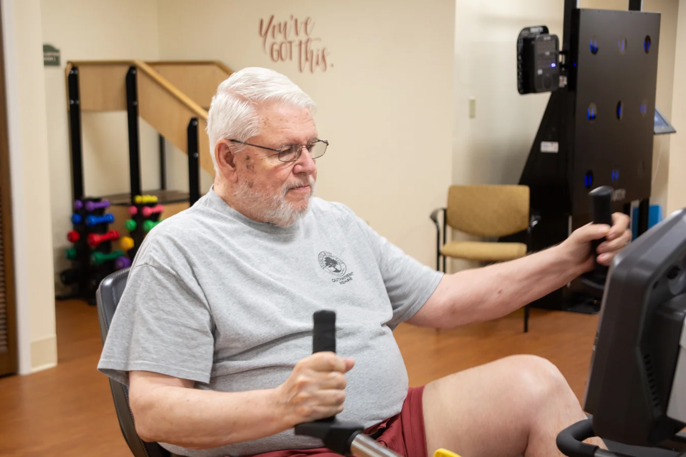 Senior man working out on equipment in the wellness center.
